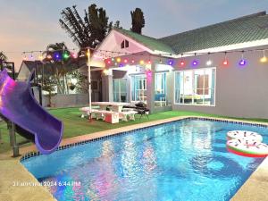a house with a swimming pool with a slide at มัลดีฟส์ เวนิซ ไมอามี่ กรีนที หัวหินพูลวิลล่า Maldive Venice Miami Green Tea Hua-Hin Pool Villa in Hua Hin