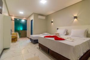 een slaapkamer met 2 bedden en een badkamer bij Hotel Pousada Tribalista in Arraial d'Ajuda +20 foto's