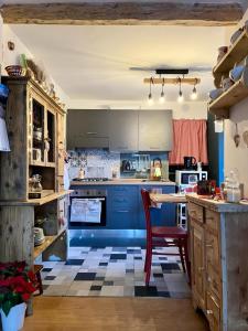 a kitchen with blue cabinets and a red chair at Il nido di Curlo in Chiesa in Valmalenco