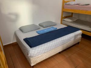 a bed with a blue blanket on top of it at 105 Apartamento exclusivo Wi-Fi in Brasilia