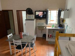 a kitchen with a table and a tv on the wall at 105 Apartamento exclusivo Wi-Fi in Brasilia
