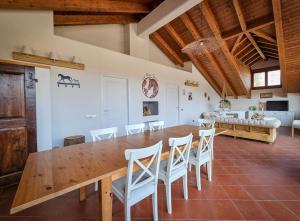 a dining room with a wooden table and white chairs at COUNTRY HOUSE LA MIA TERRA in Angera