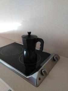 una cafetera negra sobre una estufa en Apartamentos La Pergola Castellón, en Castellón de la Plana