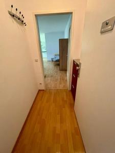 an empty room with a hallway with a hard wood floor at ADSA Apartment Linz in Linz