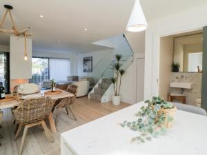 Una cocina y una sala de estar con mesa y sillas. en Driftwood, en Dawlish