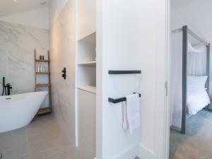 Un baño con bañera blanca y lavabo. en Driftwood, en Dawlish 25 fotos más