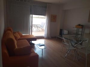 sala de estar con sofá y mesa de cristal en Apartamentos La Pergola Castellón, en Castellón de la Plana