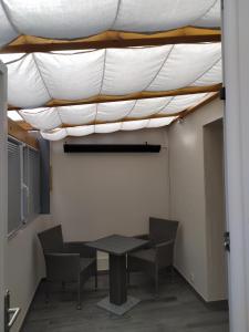 une table et des chaises dans une pièce avec plafond dans l'établissement Ferienwohnung direkt an der Nied, 