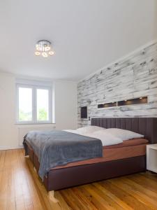 RehlingenにあるFerienwohnung direkt an der Niedの石の壁と大きなベッドのある寝室