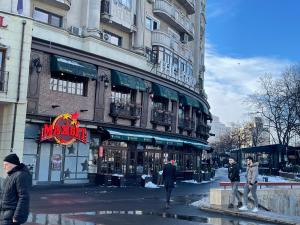 un grupo de personas caminando delante de un edificio en Black Apartament nr1, en Bucarest