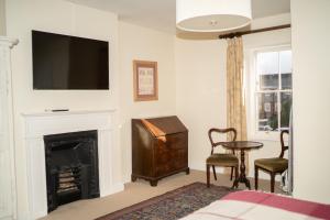 a living room with a fireplace and a television on a wall at The Bakehouse - central townhouse sleeps 8 people in Winchester