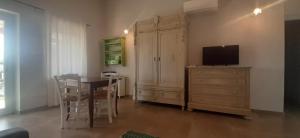 ein Esszimmer mit einem Tisch und einem TV auf einer Kommode in der Unterkunft Lispusada Agriturismo Adults Only in Biancareddu