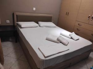 a bed with white sheets and towels on it at Ioannis & Labros House in Vlikhón