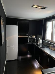 eine Küche mit einem weißen Kühlschrank und einer Mikrowelle in der Unterkunft Black Apartament nr1 in Bukarest