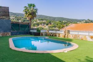 una gran piscina en un patio con césped verde en Preciosa casa en Sant Cebrià de Vallalta, en Sant Cebrià de Vallalta