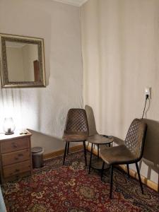 two chairs and a table in a room with a mirror at Gasthaus "Zum Goldenen Roß" in Uhlstädt