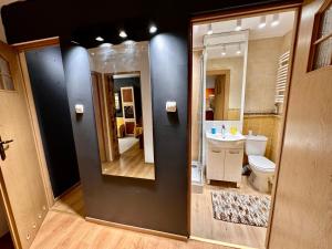 uma casa de banho com um lavatório, um WC e um espelho. em VIEW 3 fast WiFi 1Gbs 85'TV AmazonTV HBO Disney+ em Varsóvia