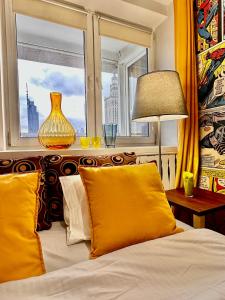 um quarto com uma cama com almofadas amarelas e uma janela em VIEW 3 fast WiFi 1Gbs 85'TV AmazonTV HBO Disney+ em Varsóvia