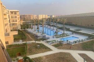 Blick auf einen Pool mit Palmen und Gebäuden in der Unterkunft cozy house in Kairo