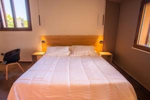 a bedroom with a large white bed with a chair at Park Hotel Bellavista in Gambarie dʼAspromonte