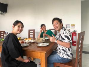 een groep mensen die aan een tafel eten bij Senanayaka Holiday Inn in Polonnaruwa