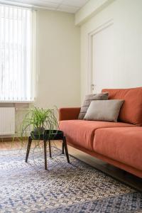 ein Wohnzimmer mit einem orangenen Sofa und einem Tisch in der Unterkunft Virumaa Hostel in Kohtla-Järve