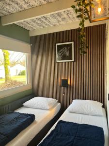 two beds in a room with a window at Huuske14 in Simpelveld