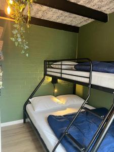 two bunk beds in a room with a green wall at Huuske14 in Simpelveld