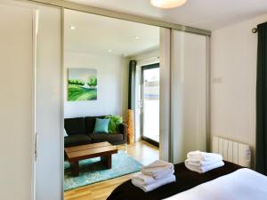 Habitación con cama y sala de estar con espejo. en Your Space Apartments - Eden House en Cambridge