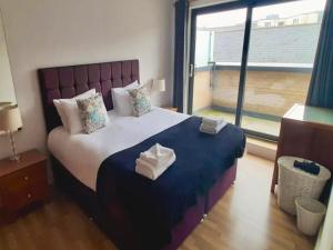 a bedroom with a large bed with towels on it at Your Space Apartments - Eden House in Cambridge