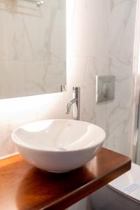 a white sink on a wooden counter in a bathroom at Fiori Hotel in Gouvia