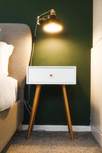 a nightstand with a light on top of it next to a bed at Modern & Stylish 1 bedroom flat in Bristol in Bristol