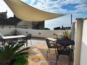 eine Terrasse mit Tischen und Stühlen auf dem Balkon in der Unterkunft Casa Sebastian A in Vietri