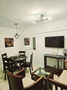 a dining room with two tables and a flat screen tv at Camella Northpoint Bajada Near Sm lanang 2bedroom unit with balcony Davao in Davao City