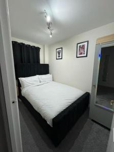 a bedroom with a bed with a black headboard at Greatmindz abode in Kingshurst