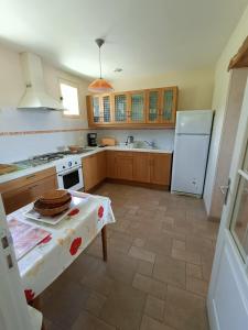 een keuken met een tafel en een witte koelkast bij La Belle de la Gaieté in Loches