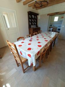 stół z białą tkaniną z czerwonymi różami w obiekcie La Belle de la Gaieté w mieście Loches