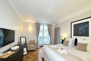 a hotel room with a large bed and a television at 1572C - Luxembourg Garden Paris Olympic 2024 in Paris