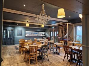 a dining room with tables and chairs and a chandelier at Royal Hotel, Bar & Grill in Purfleet
