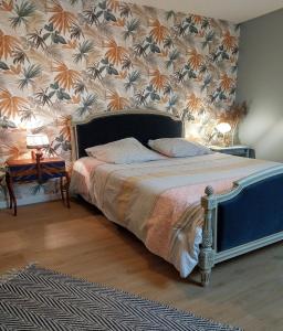 1 dormitorio con 1 cama y papel pintado con motivos florales en La Osmonière - Maison 6 personnes - Tout inclus, en Saint-Méloir-des-Ondes