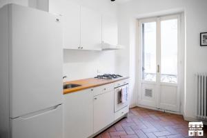 uma cozinha branca com um lavatório e um fogão em TORRETTA 4 by Design Studio em Bellano
