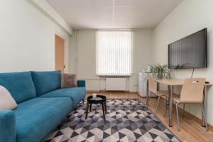a living room with a blue couch and a table at Virumaa Hostel in Kohtla-Järve
