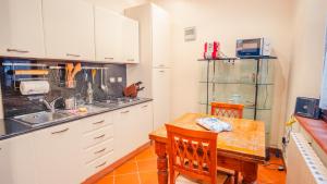 a kitchen with white cabinets and a wooden table at Piazza Grande - Italian Homing in Bologna +18 photos