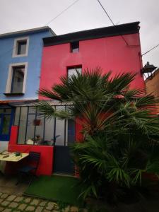 una casa colorida con una palmera delante de ella en Trentemoult : Charmante grande maison avec vue sur Loire 105 m2 en Rezé