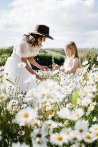 una donna e una ragazza in un campo di fiori di Rame Barton Guest House and Pottery a Cawsand
