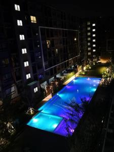 a swimming pool with blue lights in a city at night at I Condo Suvarnabhumi Airport in Bangkok