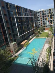 a large apartment building with a swimming pool in front of it at I Condo Suvarnabhumi Airport in Bangkok