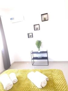 a bedroom with a bed with two towels and a table at 3 bdr spacious apt in praia in Praia