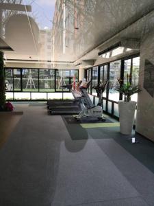 a gym with a treadmill in a building with windows at I Condo Suvarnabhumi Airport in Bangkok