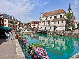 une rivière dans une ville avec un groupe de bâtiments dans l'établissement Campanile Annecy - Cran Gevrier, à Annecy